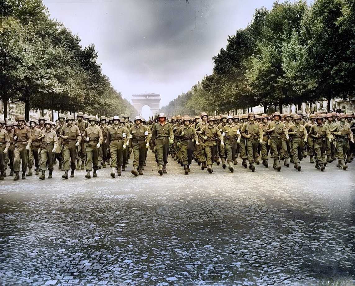 The same 1944 victory parade colorized: olive uniforms, summer trees and the Arc de Triomphe
