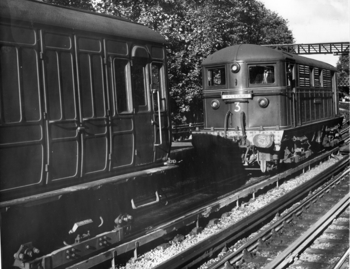 A black-and-white 1961 photograph of an electric train at a railway changeover
