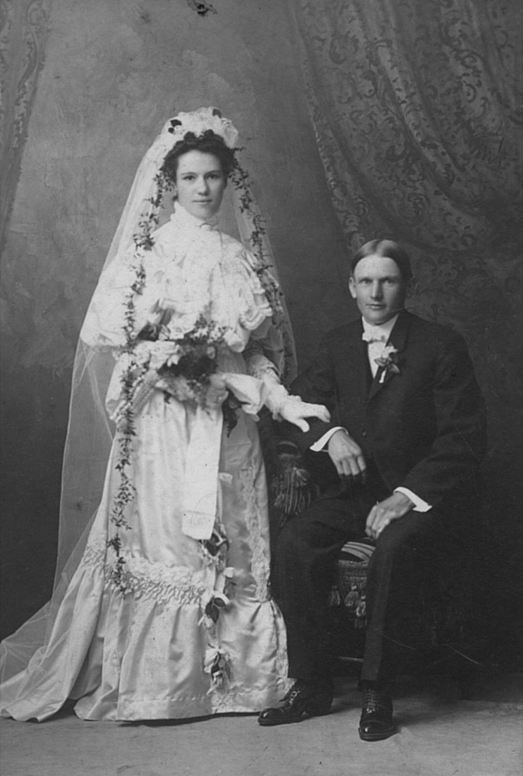A black-and-white c.1900 studio wedding portrait of a couple